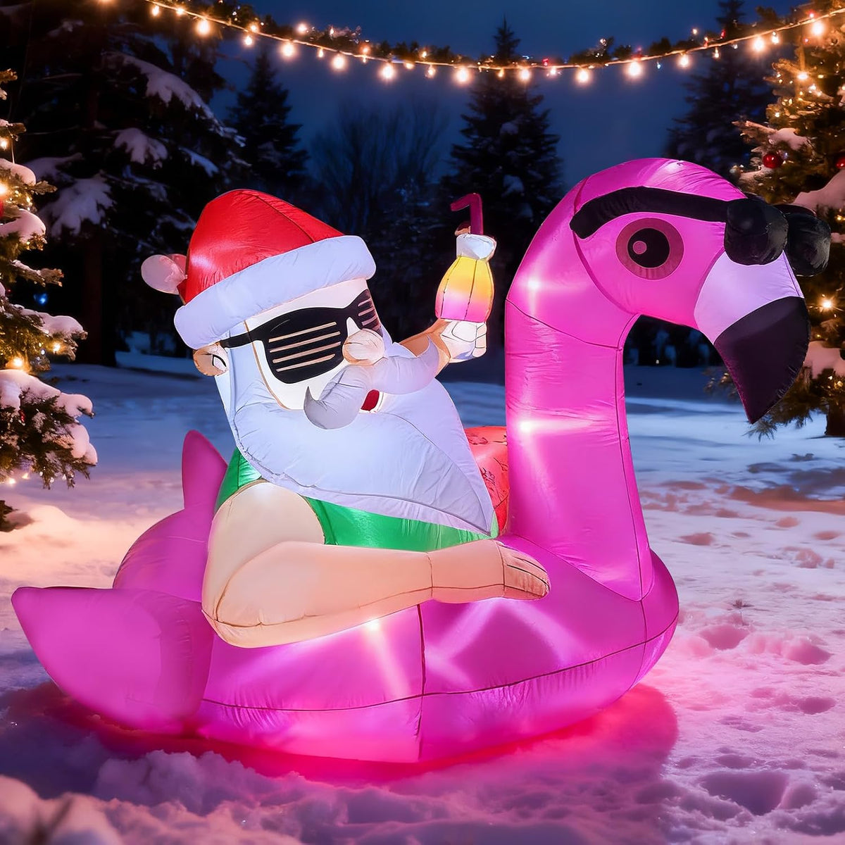 Santa in sunglasses lounging on a pink flamingo float inflatable in the snow