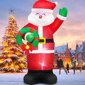 Giant Santa inflatable waving and holding a wreath in a snowy town square