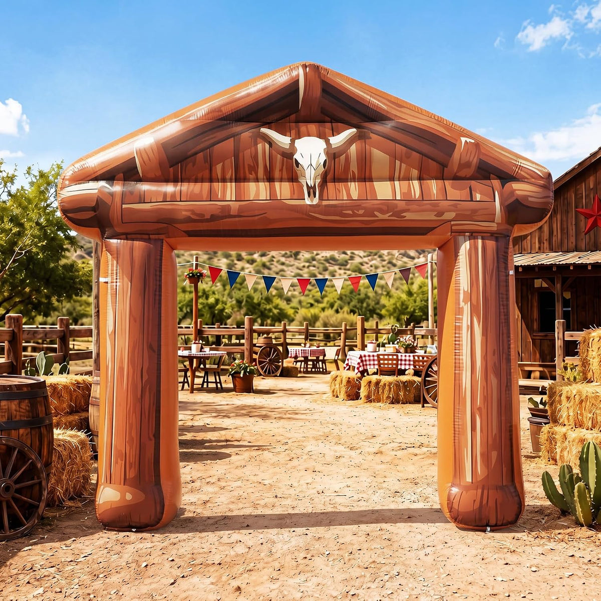 Wood-look ranch gate inflatable arch with a longhorn skull at a western ranch party