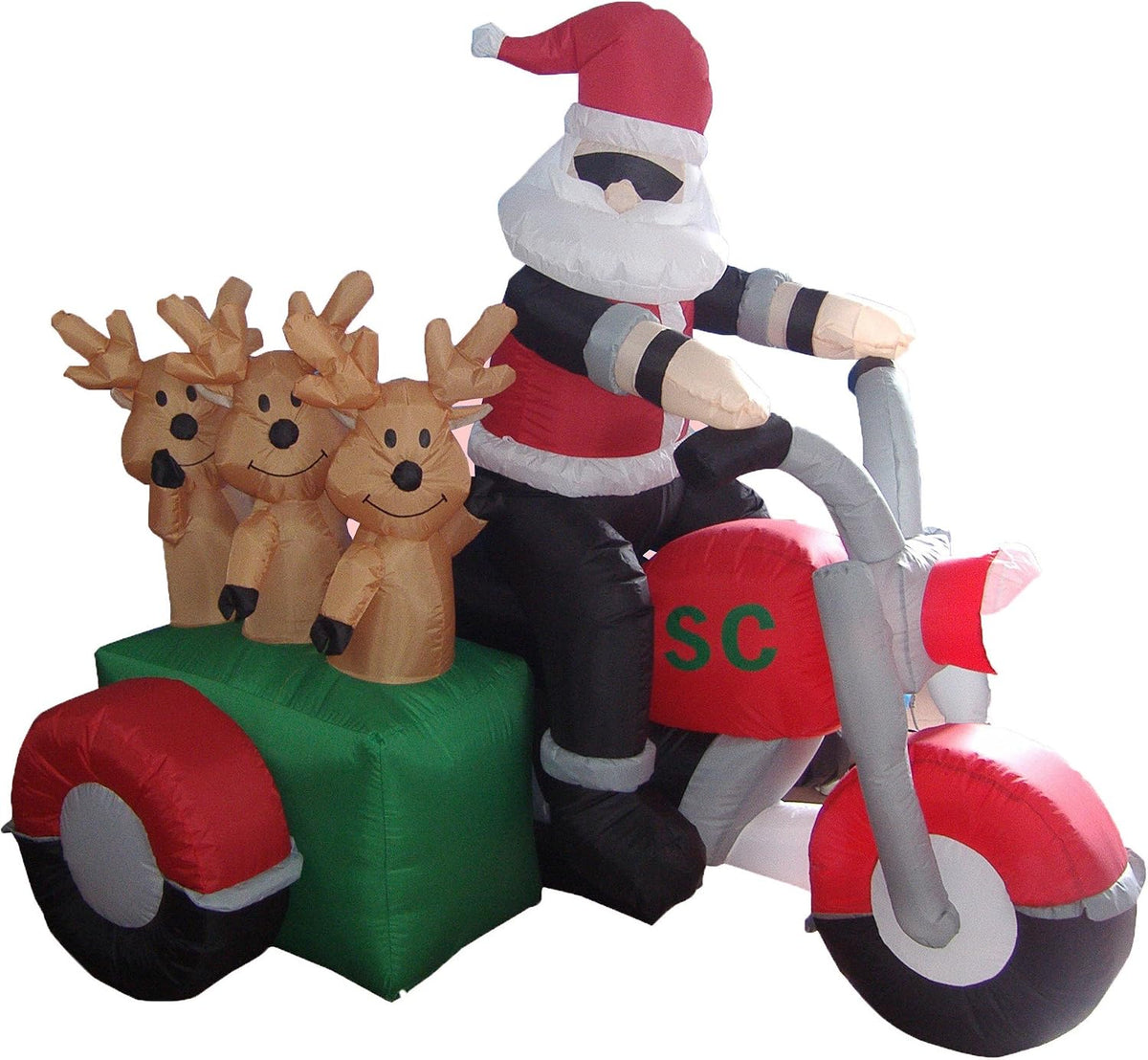 Santa in sunglasses on a red motorcycle with three reindeer in a green sidecar