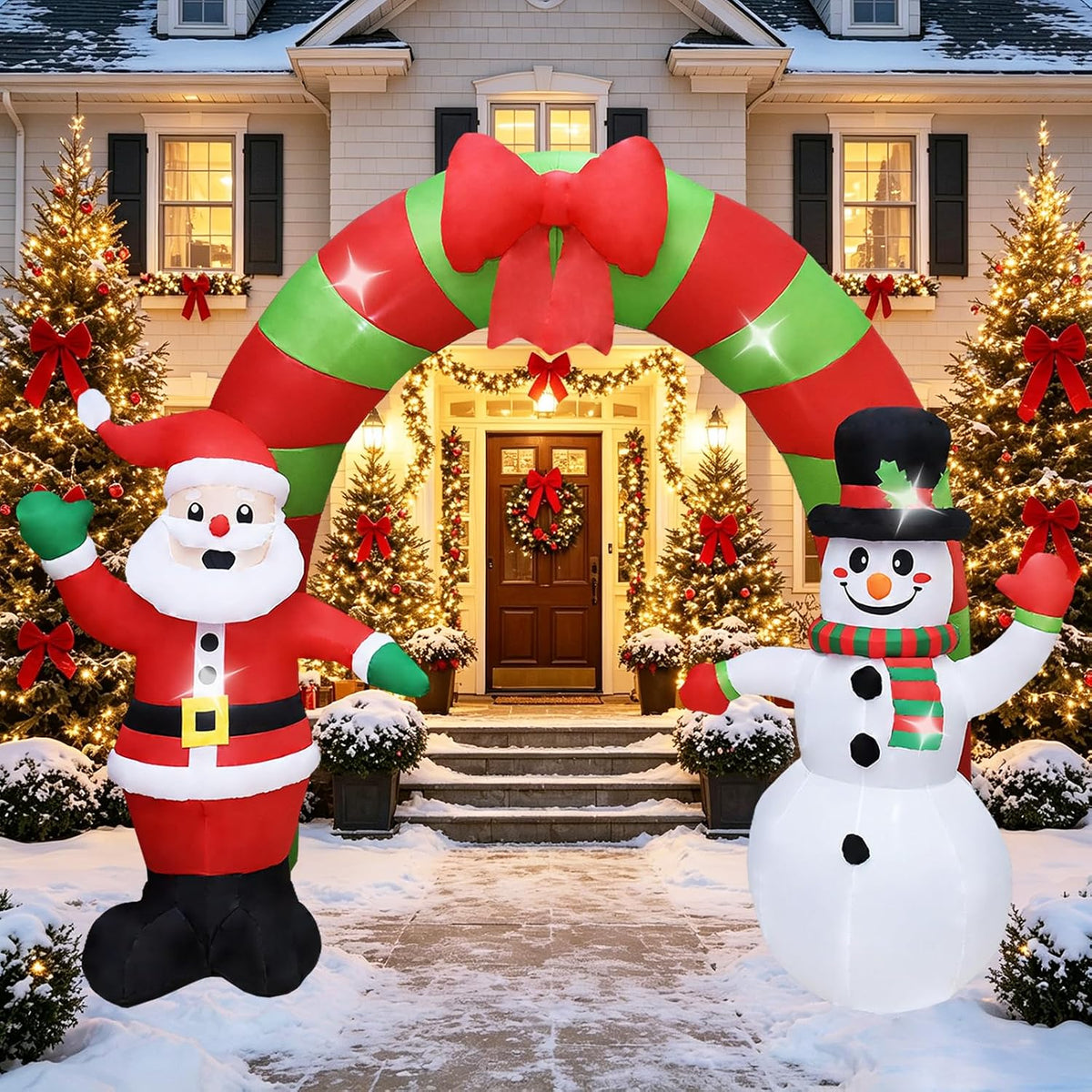 Green and red striped Christmas arch inflatable with a bow, Santa and a snowman over a snowy front walk