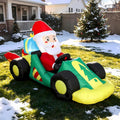 Santa driving a green and yellow race car inflatable in a snowy yard