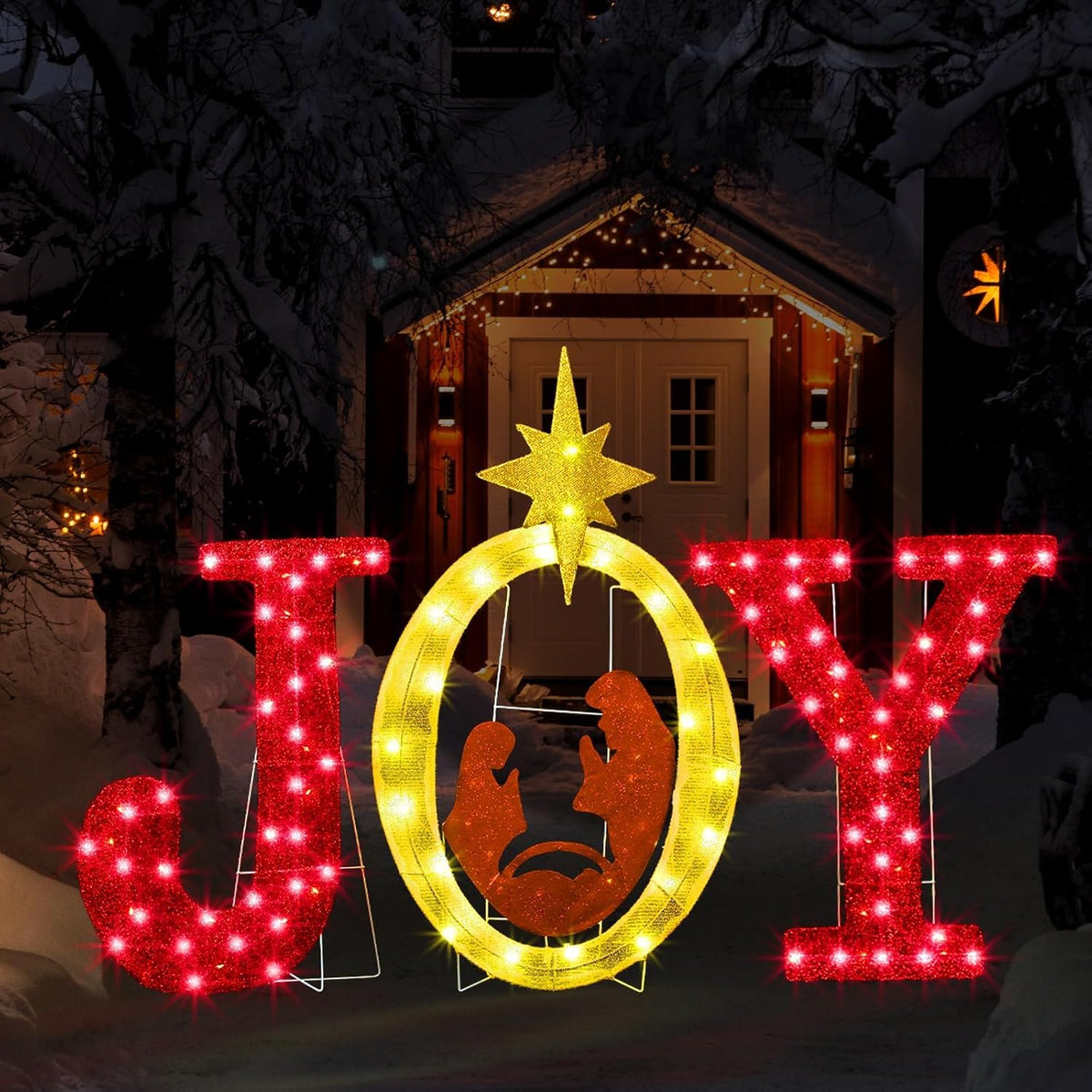 Red lighted JOY letters with a gold-lit O framing a nativity scene and a star at night