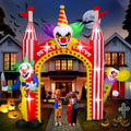 Red and yellow circus clown arch inflatable with a clown face on top and clowns at each side at night