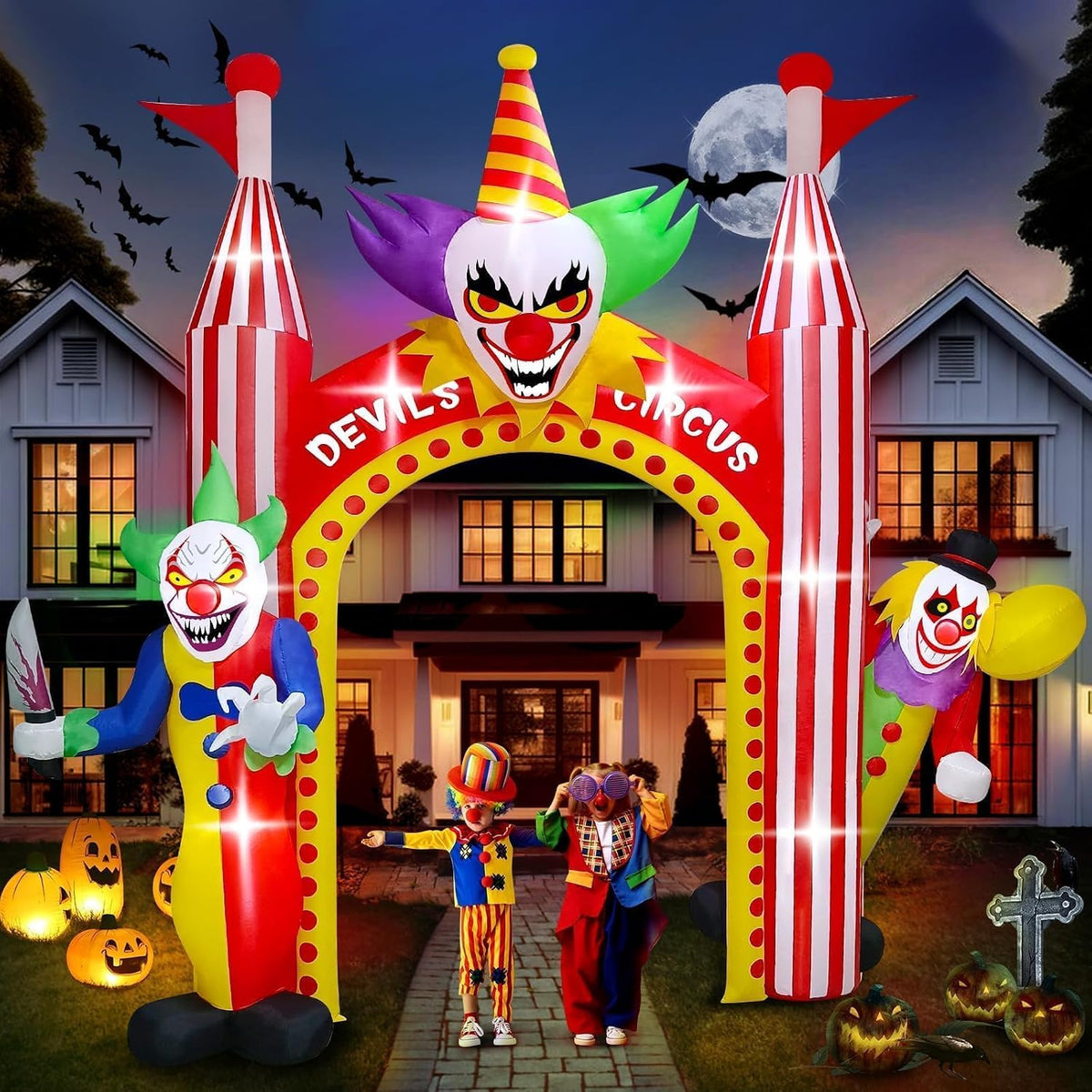 Red and yellow circus clown arch inflatable with a clown face on top and clowns at each side at night