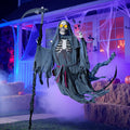Skeletal grim reaper prop in tattered robes with a scythe floating in front of a house at night